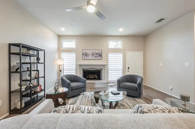 a living room with furniture a fireplace and a large window
