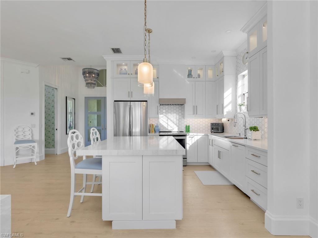 4304 Kensington High Street Naples, FL 34105 - Photo 11 of 40 a large white kitchen with cabinets a sink and a stove