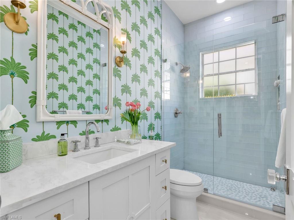 4304 Kensington High Street Naples, FL 34105 - Photo 24 of 40 a bathroom with a sink a toilet and shower