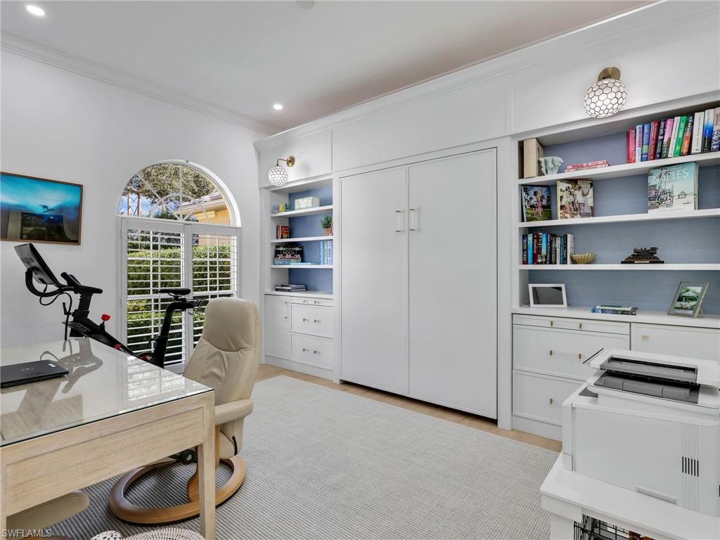 4304 Kensington High Street Naples, FL 34105 - Photo 5 of 40 a view of a workspace with furniture and a bookshelf