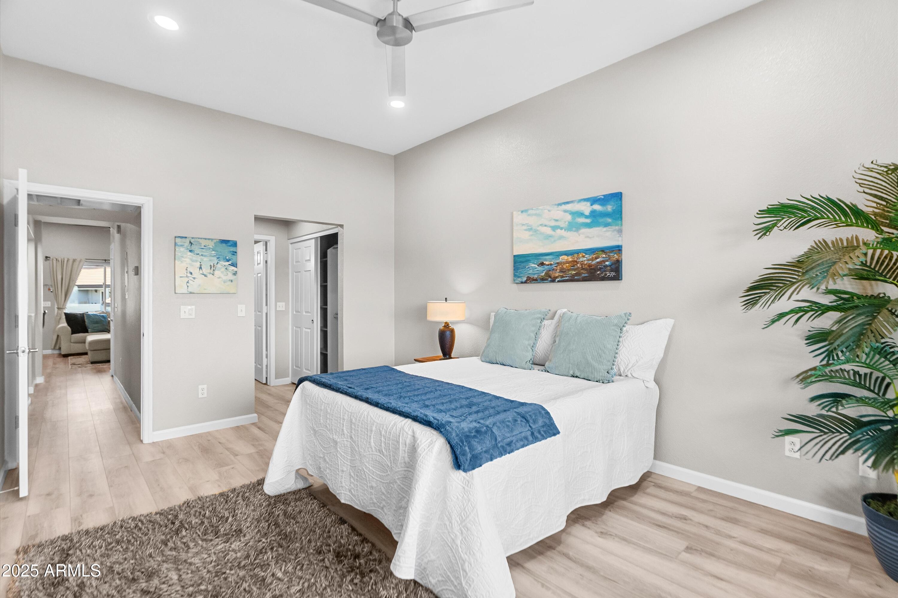 1331 West Baseline Road, Unit 338 Mesa, AZ 85202 - Photo 11 of 28 a spacious bedroom with a large bed a potted plant and attached bathroom
