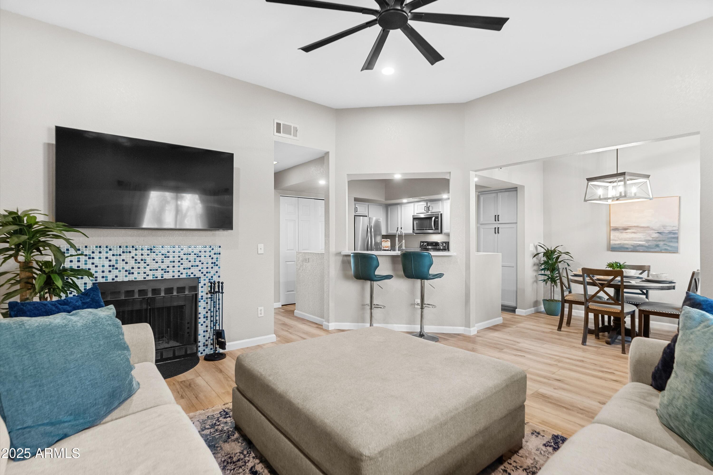 1331 West Baseline Road, Unit 338 Mesa, AZ 85202 - Photo 3 of 28 a living room with furniture a fireplace and a flat screen tv