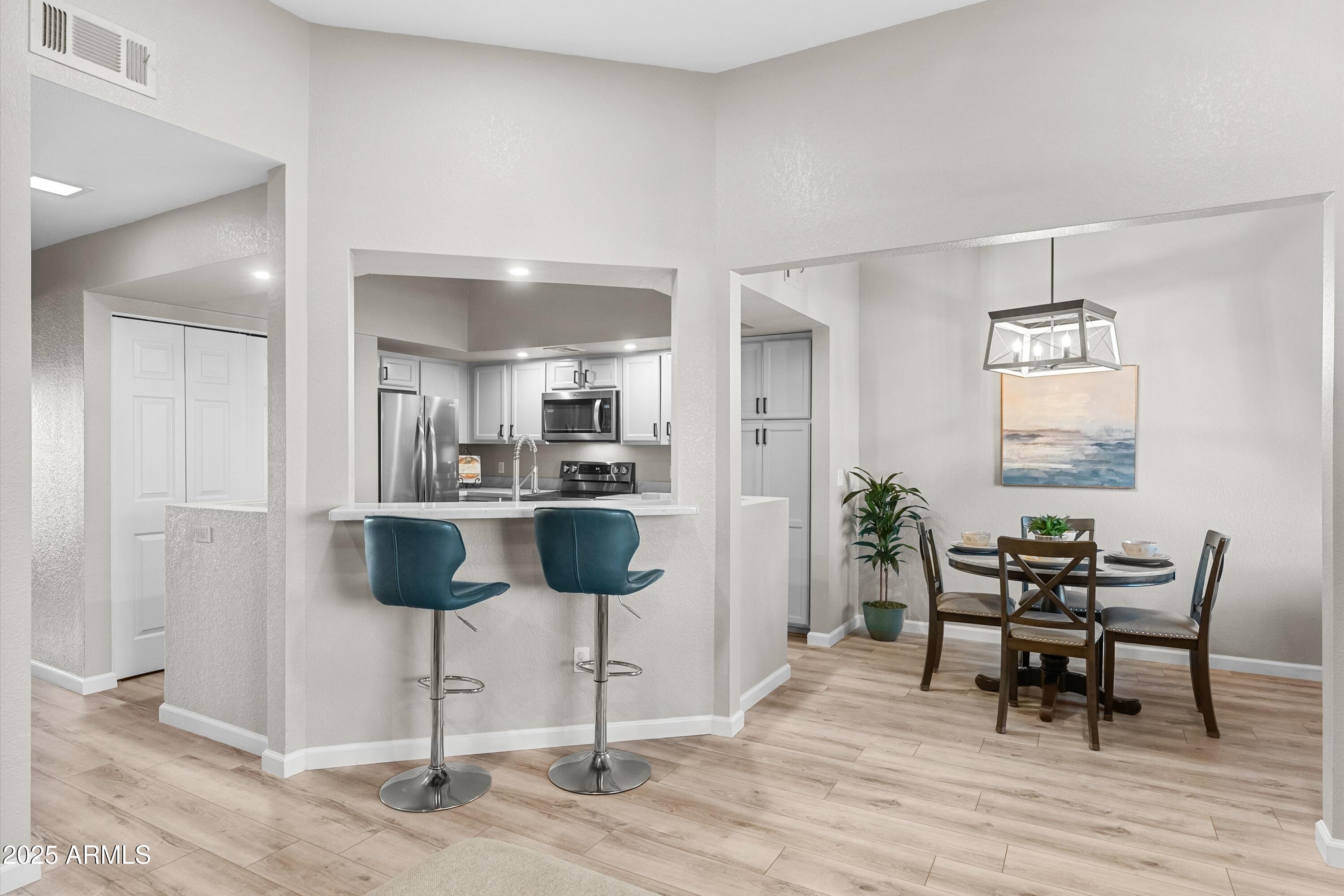 1331 West Baseline Road, Unit 338 Mesa, AZ 85202 - Photo 5 of 28 a view of a dining room with furniture and wooden floor