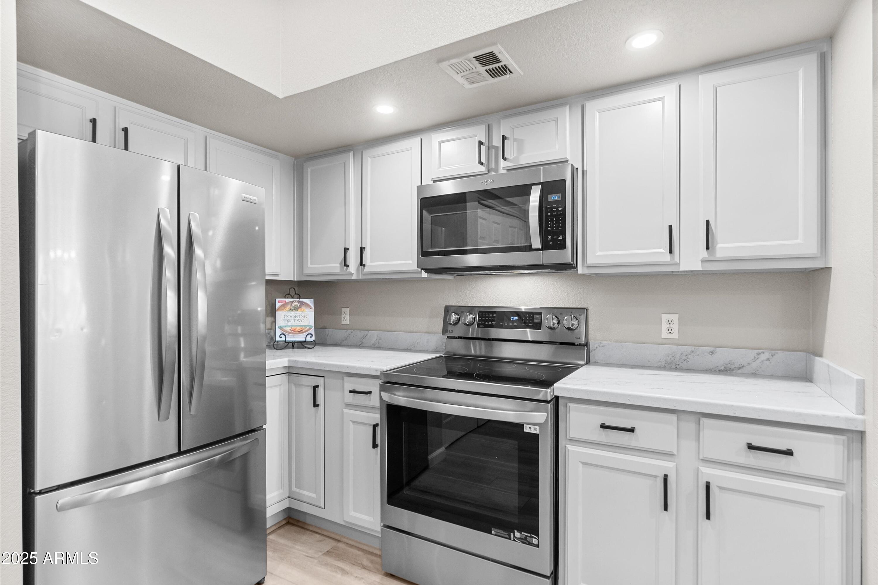 1331 West Baseline Road, Unit 338 Mesa, AZ 85202 - Photo 7 of 28 a kitchen with cabinets stainless steel appliances and a counter space