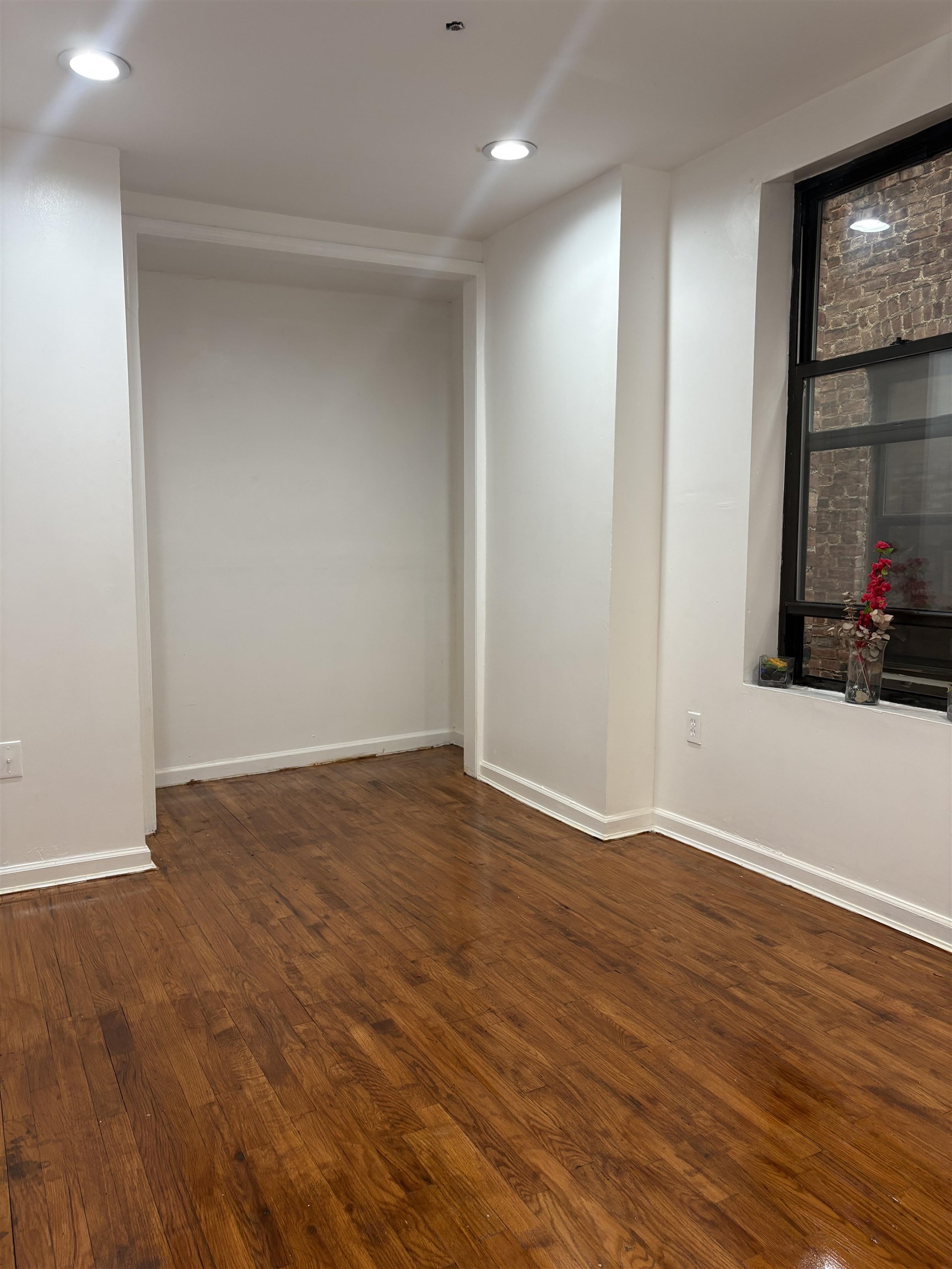 77 Crescent Avenue, Unit 5 Jersey City, NJ 07304 - Photo 13 of 18 a view of an empty room with wooden floor and a window