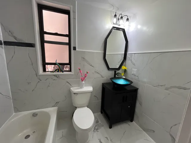a bathroom with a toilet sink and mirror