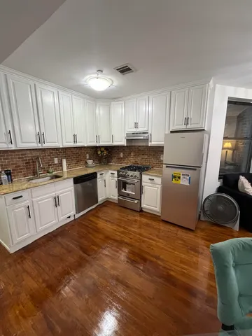 a kitchen with white cabinets and white appliances