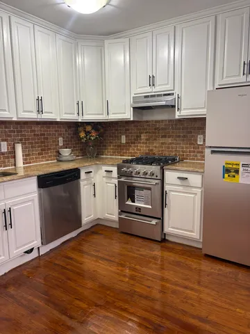 a kitchen with granite countertop wooden cabinets and a stove