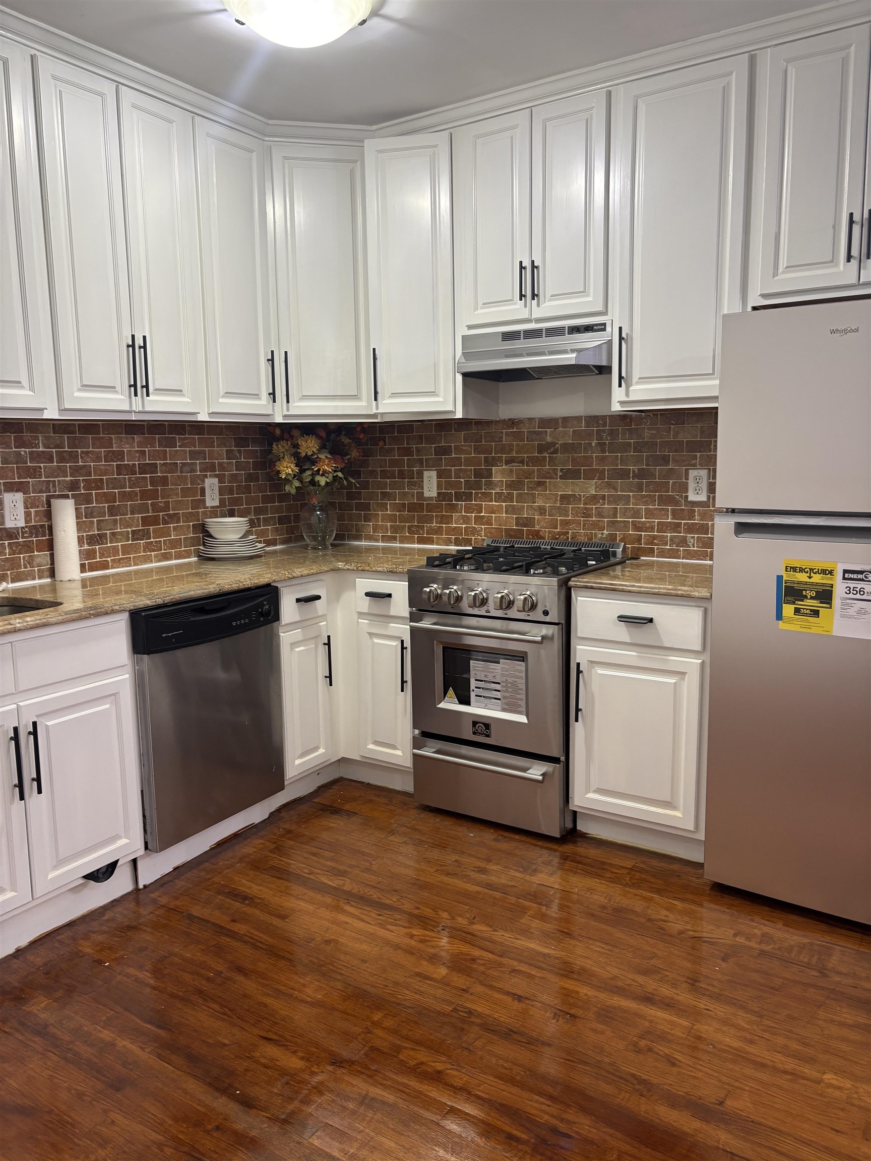 77 Crescent Avenue, Unit 5 Jersey City, NJ 07304 - Photo 9 of 18 a kitchen with granite countertop wooden cabinets and a stove
