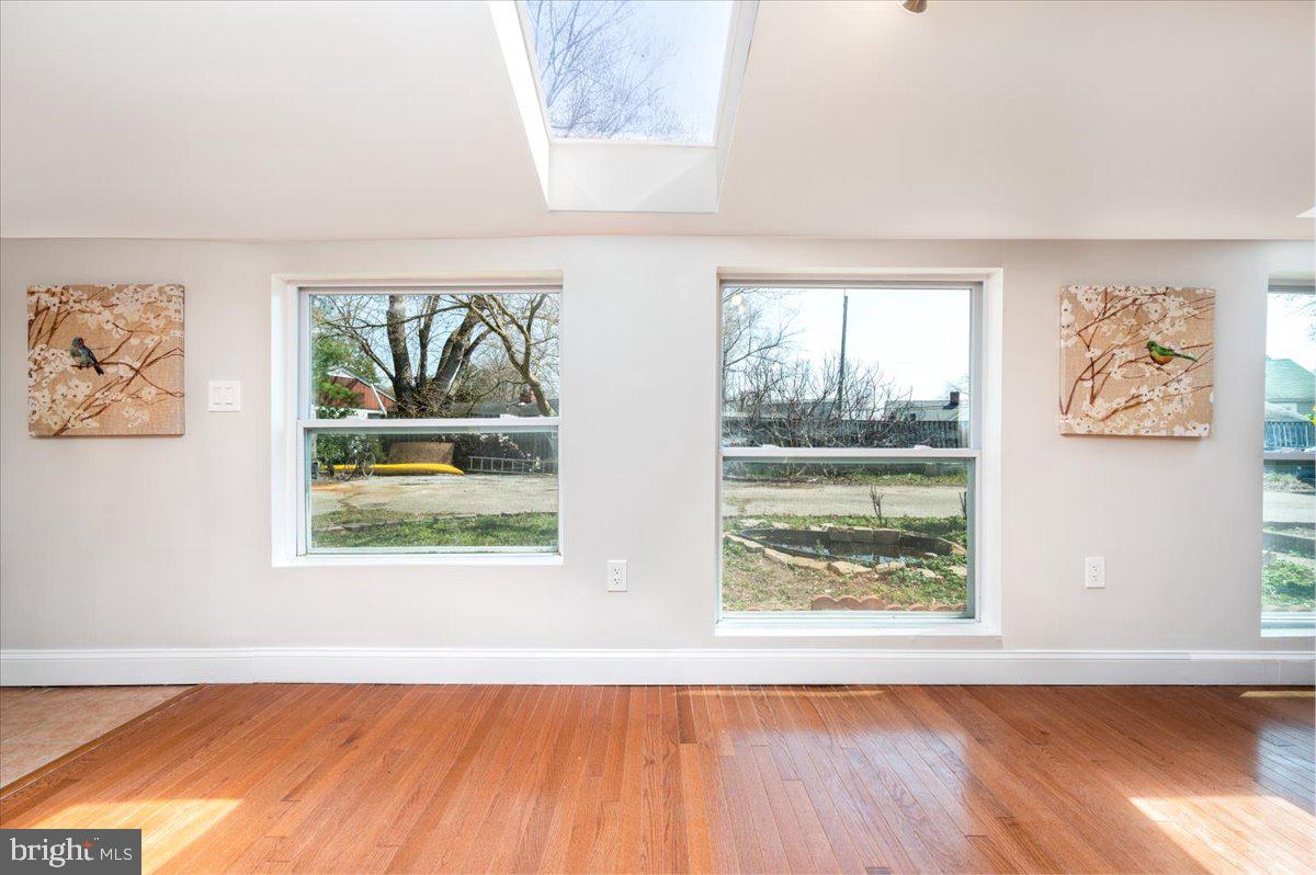 626 Clark Avenue Deale, MD 20751 - Photo 12 of 74 an empty room with wooden floor a painting on the wall and a window