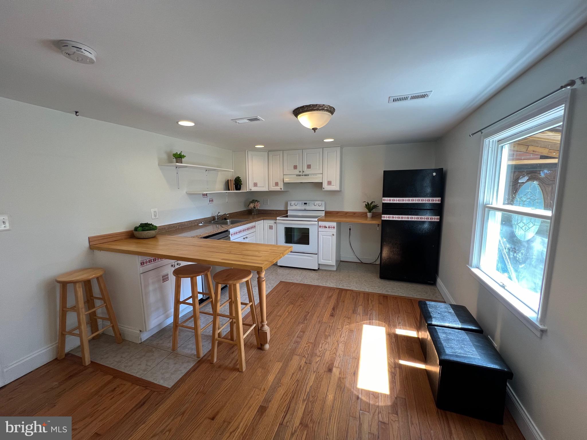 626 Clark Avenue Deale, MD 20751 - Photo 35 of 74 a kitchen with stainless steel appliances granite countertop a kitchen island hardwood floor sink stove dining table and chairs