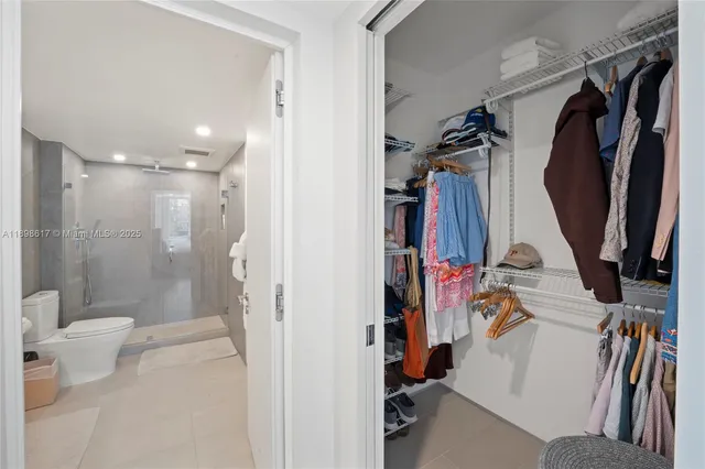 a view of walk in closet with clothes and shoes