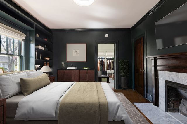 a bedroom with a large bed and a fireplace