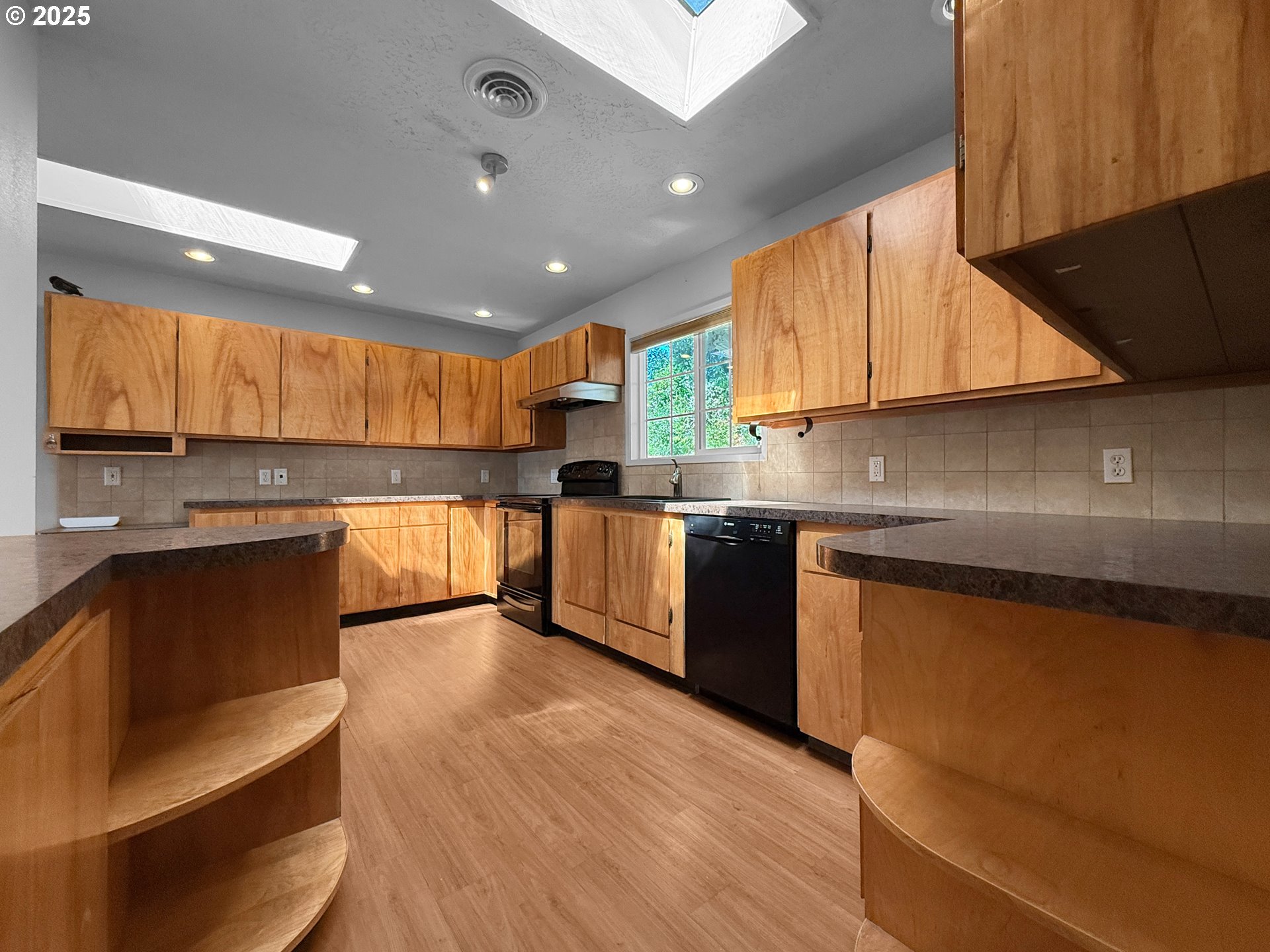 96741 Duley Creek Road Brookings, OR 97415 - Photo 10 of 36 a kitchen with stainless steel appliances kitchen island granite countertop a stove a sink and a microwave