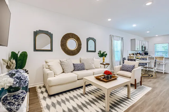 a living room with furniture a rug and a potted plant