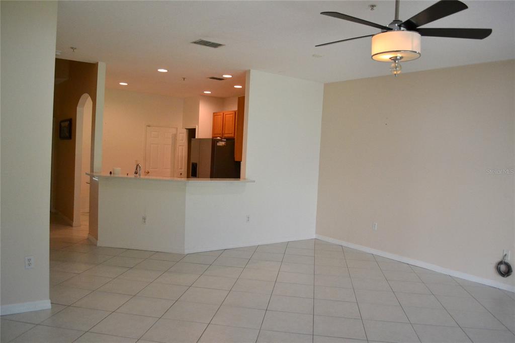 11235 Kapok Grand Circle Madeira Beach, FL 33708 - Photo 7 of 34 an empty room with kitchen view and a refrigerator