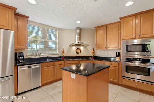a kitchen with granite countertop a sink stainless steel appliances and cabinets