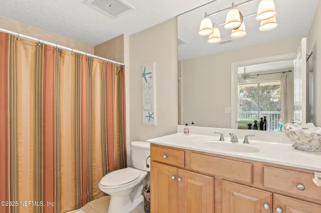 a bathroom with a double vanity sink toilet and a mirror