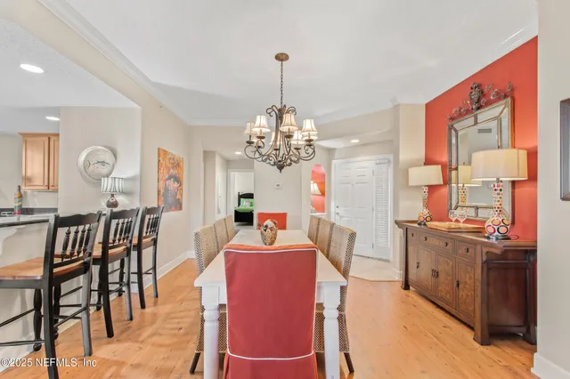 a view of a dining room and livingroom with furniture a chandelier and wooden floor