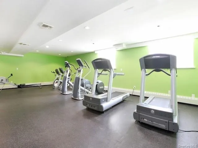 a living room with furniture pool table and gym equipment