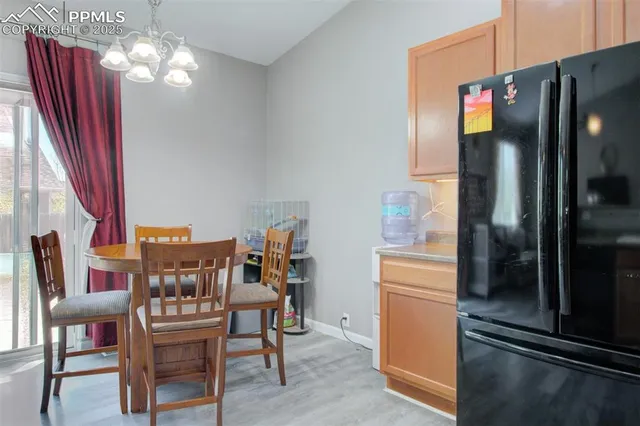 a dining room with furniture a chandelier and wooden floor