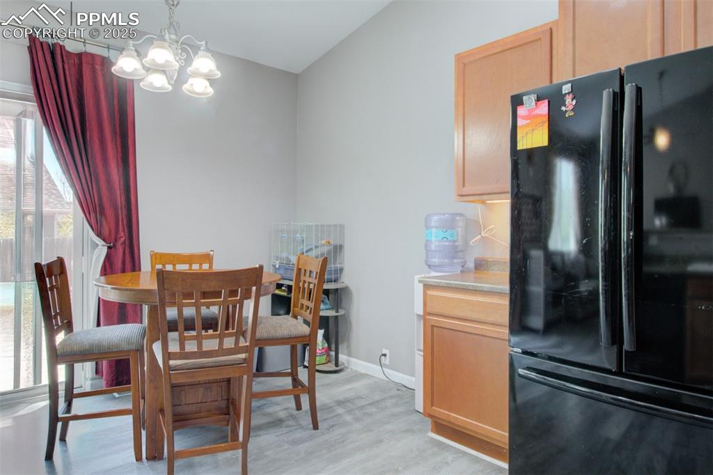 7627 Loopout Grove Peyton, CO 80831 - Photo 11 of 21 a dining room with furniture a chandelier and wooden floor