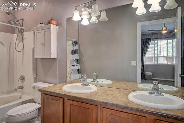 a bathroom with a granite countertop sink a toilet and a mirror