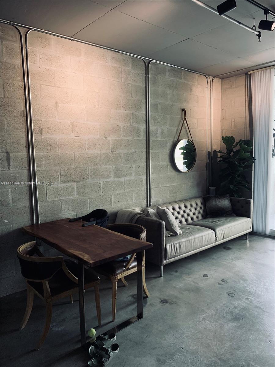 Edgewater Miami, FL 33137 - Photo 11 of 14 a table chair sitting in a room next to a window