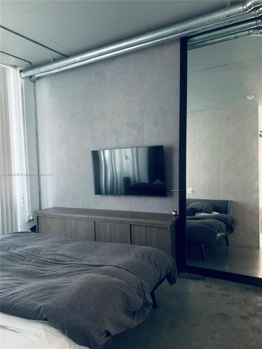 Edgewater Miami, FL 33137 - Photo 10 of 14 a bedroom with a bed and a walk in closet