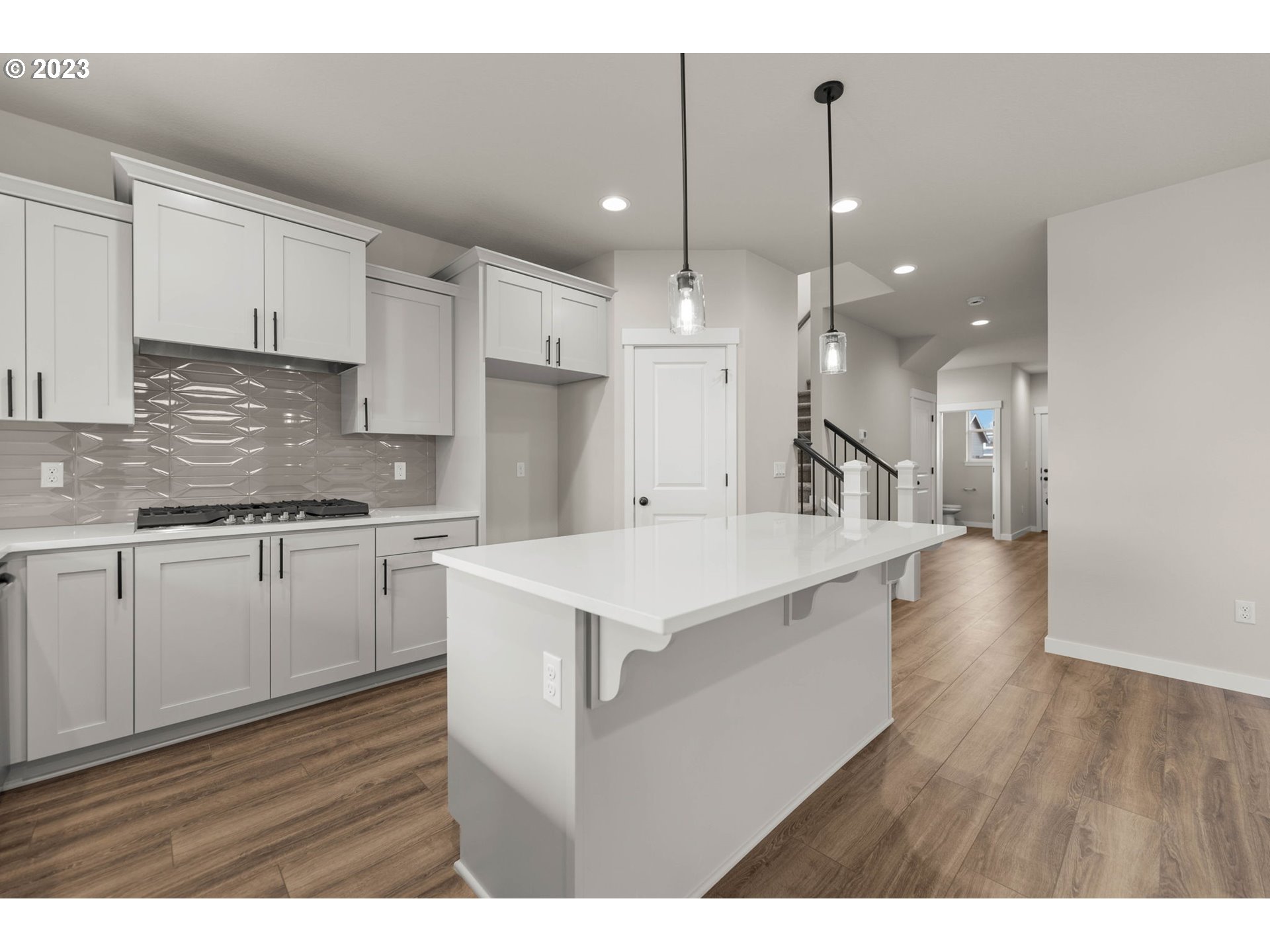 8847 North 3rd Circle Ridgefield, WA 98642 - Photo 8 of 40 a large kitchen with cabinets wooden floor and a sink