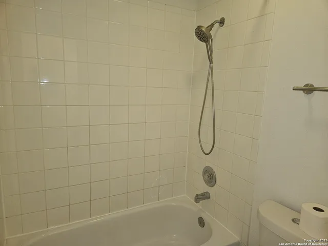 a white toilet sitting next to a white sink and vanity