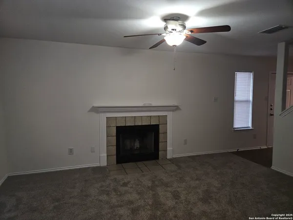 an empty room with a fireplace and fan