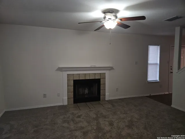 an empty room with a fireplace and fan