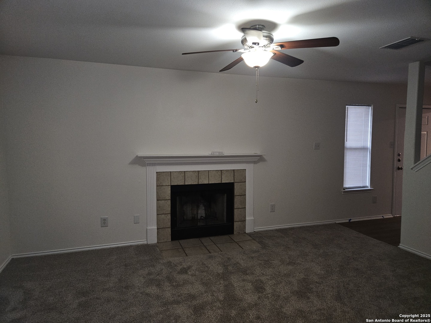 7715 Rustic Lane San Antonio, TX 78230 - Photo 3 of 26 an empty room with a fireplace and fan