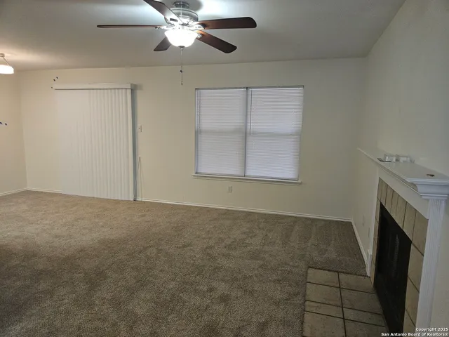 a view of an empty room with a fireplace and a window