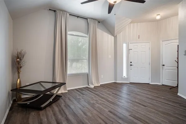 a view of a room with wooden floor and a ceiling fan
