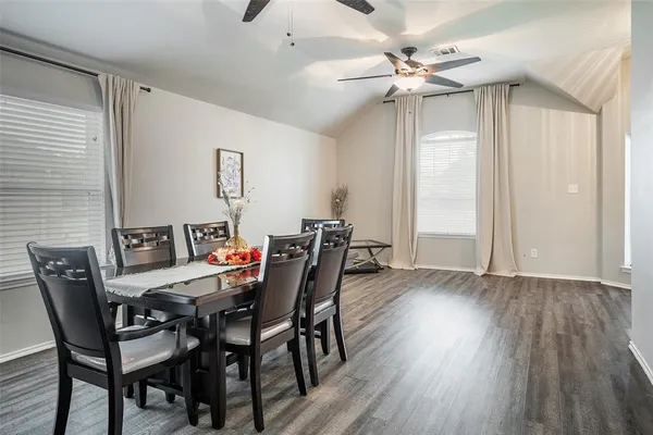 a view of a dining room with furniture and a chandelier fan