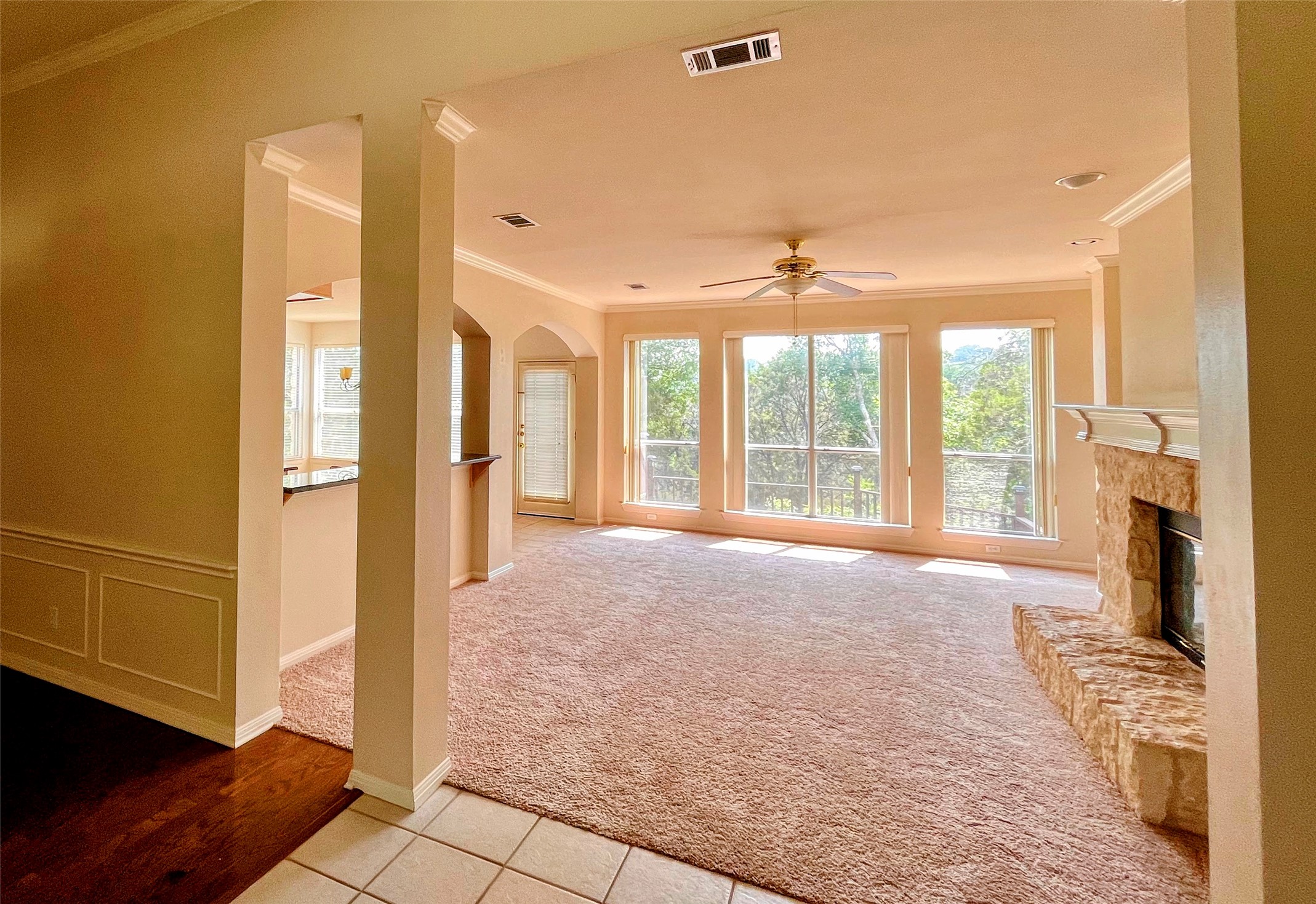 9405 Ashton Ridge Austin, TX 78750 - Photo 5 of 22 A spacious living area with a stone fireplace and expansive windows overlooking natural surroundings.