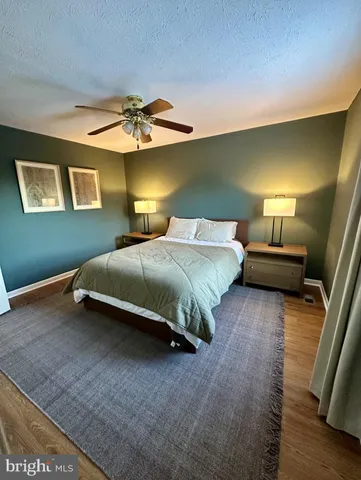 a bedroom with a bed and a lamp on the dresser