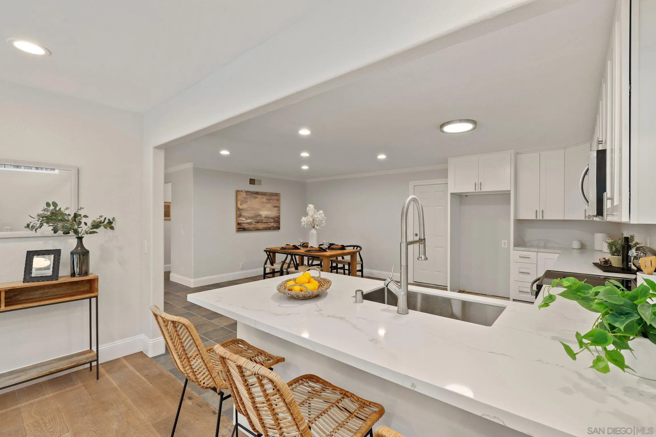 1725 Deerfield Road Encinitas, CA 92024 - Photo 8 of 31 a kitchen with stainless steel appliances a dining table chairs and white cabinets