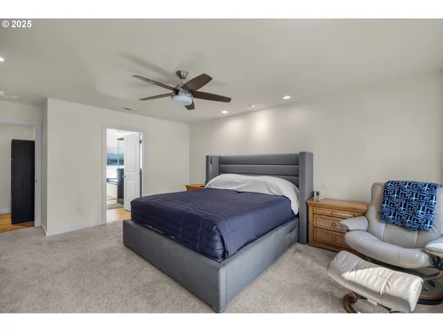 a spacious bedroom with a bed a couch and a ceiling fan