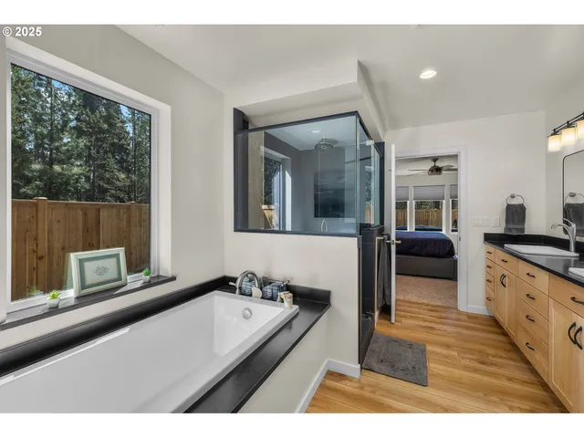a en suite bathroom with a granite countertop sink and a large mirror