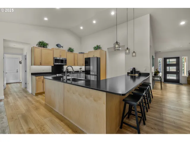 a kitchen with stainless steel appliances kitchen island granite countertop a sink and cabinets