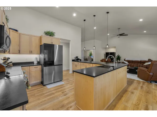 a kitchen with stainless steel appliances granite countertop a sink refrigerator and microwave
