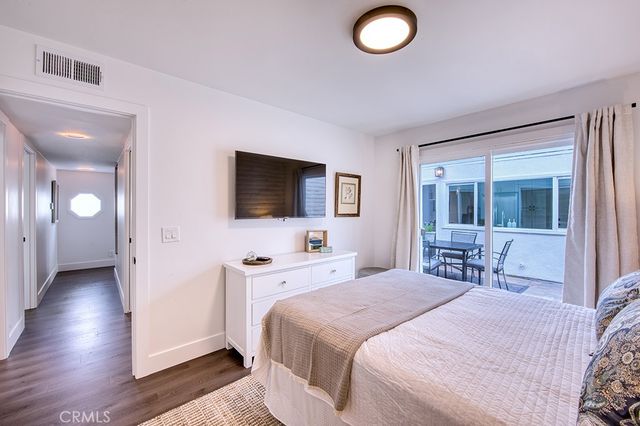 a bedroom with a bed and a flat tv screen on dresser