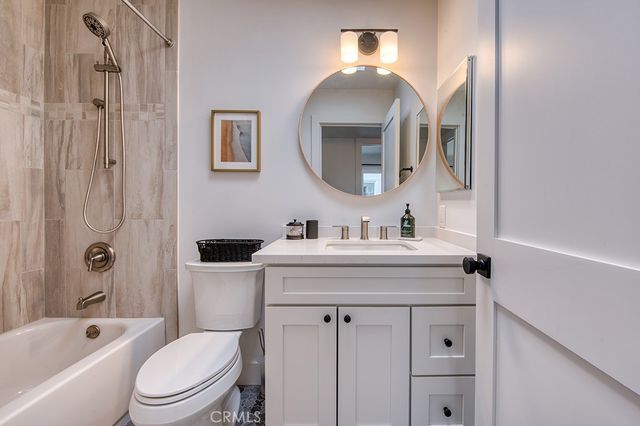 a bathroom with a sink toilet vanity and shower