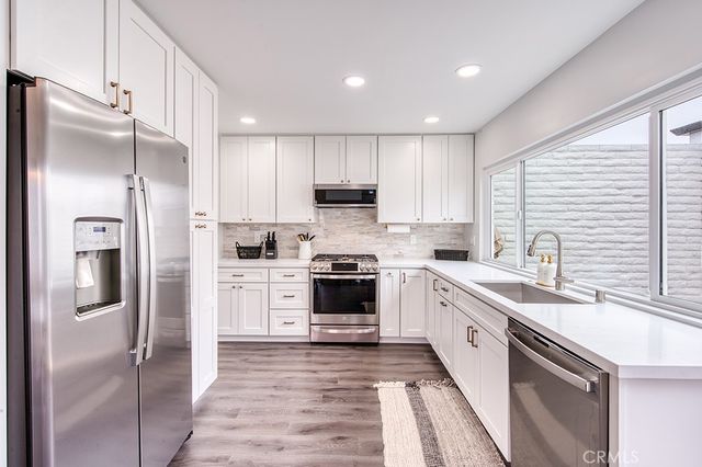 a kitchen with a refrigerator sink and cabinets