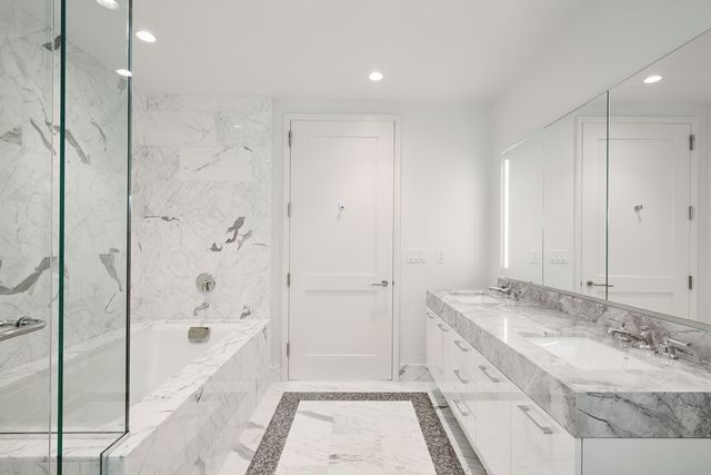 a bathroom with a granite countertop sink a mirror and a bathtub