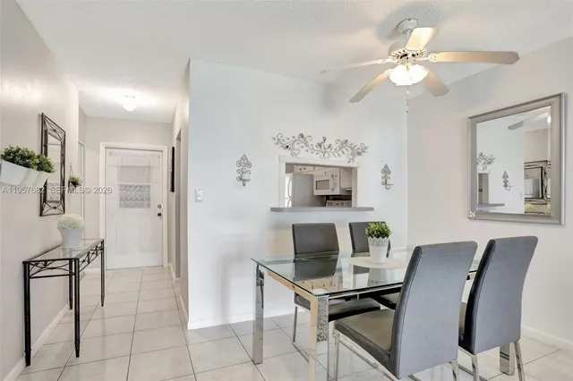 a view of a dining room with furniture and a chandelier fan