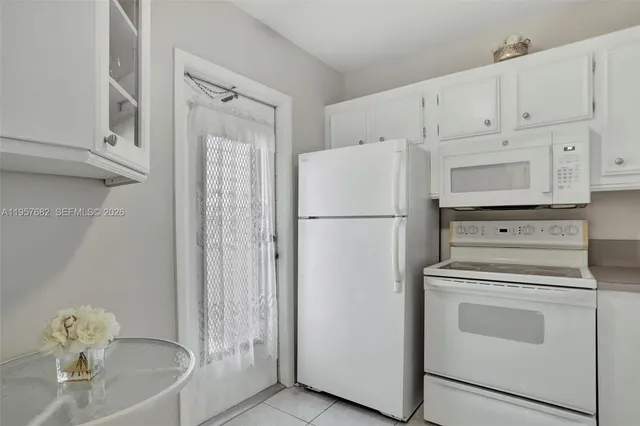 a kitchen with white cabinets and white appliances